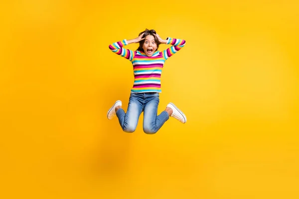 Tamanho total do corpo foto de pular alta aluna louca mantendo a cabeça com as mãos gritando isolado no fundo de cor amarela vibrante — Fotografia de Stock
