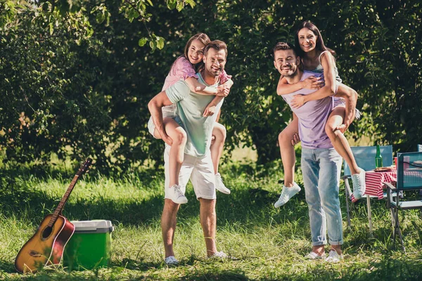 Pełna długość zdjęcie firmy czterech członków zabawy siedzi piggyback na zewnątrz zewnątrz ogród park las — Zdjęcie stockowe