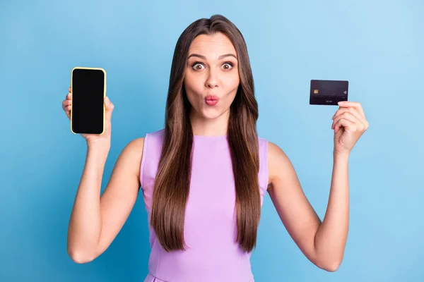 Фотопортрет збудженої дівчини, що показує екран мобільного телефону копія кредитної картки банку ізольовано на яскраво-блакитному фоні — стокове фото