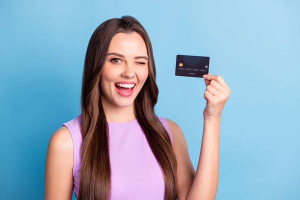 Фотопортрет девушки, подмигивающей, показывающей дебетовую банковскую карту, улыбающейся изолированно на ярком голубом фоне — стоковое фото