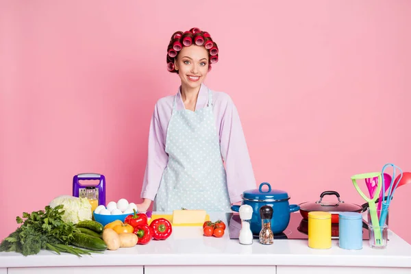 Portret van tevreden persoon staan achter bureau het maken van voedsel geïsoleerd op pastel roze kleur achtergrond — Stockfoto