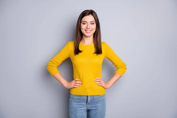 Foto di giovane attraente felice sorridente allegra bella ragazza indossare maglione giallo e jeans isolato su sfondo di colore grigio — Foto Stock