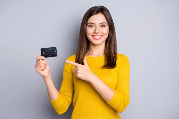 Портрет милой веселой девушки, держащейся за руки и демонстрирующей решение для банковской карты на сером фоне — стоковое фото