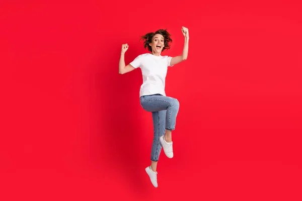Longitud completa vista del tamaño del cuerpo de la chica alegre atractiva saltando regocijo divertirse aislado sobre fondo de color rojo brillante — Foto de Stock