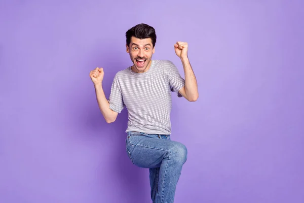 Foto de feliz alegre positivo animado louco homem levantar punhos na vitória triunfo isolado no fundo cor violeta — Fotografia de Stock