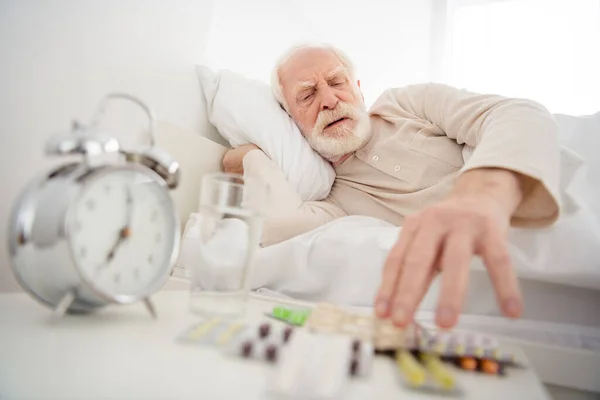 老年人养老金领取者躺在家里休息不好的照片不健康的样子吃药止痛药 — 图库照片