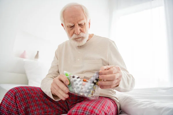 老年人养老金领取者不快乐的照片不健康的不健康的相貌药物止痛药躺在家里 — 图库照片
