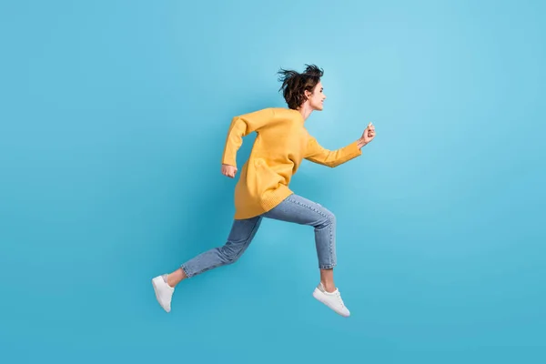 Corpo de comprimento total perfil lateral foto da menina feliz correndo rápido salto alto isolado no fundo de cor azul brilhante — Fotografia de Stock