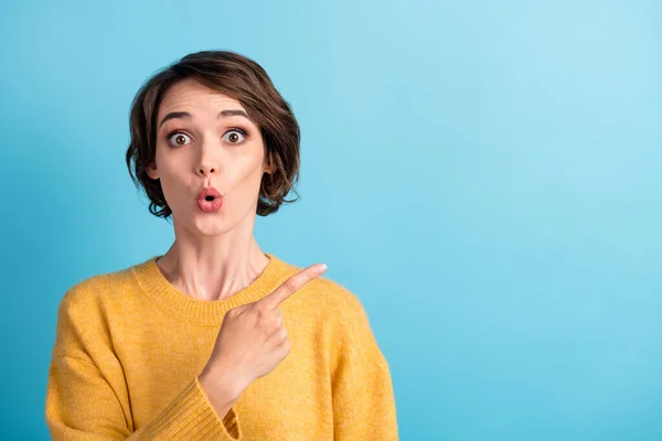 Photo portrait of shocked amazed female student with short hair showing copyspace staring isolated on bright blue color background