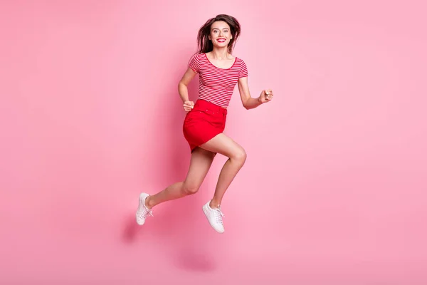 Foto sisi profil penuh dari pemuda menarik suasana hati yang ceria gadis energik melompat gerakan terisolasi di warna merah muda latar belakang — Stok Foto