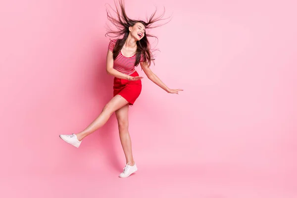 Pełnowymiarowe zdjęcie młodej atrakcyjnej aktywnej energetycznie szalonej uśmiechniętej dziewczyny z latającymi włosami odizolowanej na różowym tle — Zdjęcie stockowe