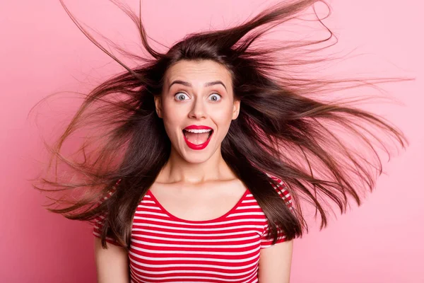 Portrait of young beautiful amazed shocked surprised woman with red lipstick look camera flying hair isolated on pink color background — Stock Photo, Image