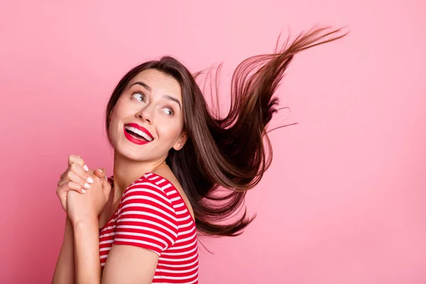 Foto de jovem bonito sorrindo positivo adorável menina olhar copyspace voando cabelo isolado no fundo cor-de-rosa — Fotografia de Stock