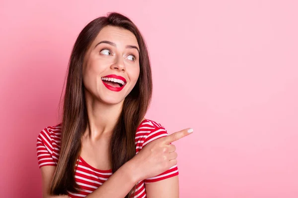 Foto de feliz alegre bonita mulher olhar ponto anúncio espaço vazio desgaste vermelho listrado t-shirt isolada no fundo cor-de-rosa — Fotografia de Stock