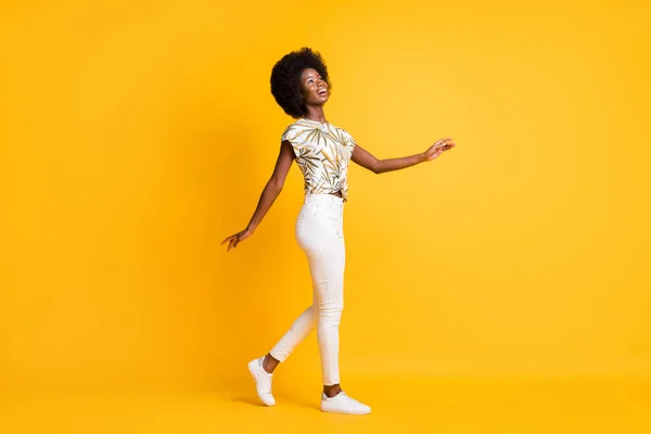 フルサイズプロフィール写真の楽観的な可愛い女性の歩行見て空のスペースドレスtシャツスニーカーパンツ孤立した黄色の背景 — ストック写真