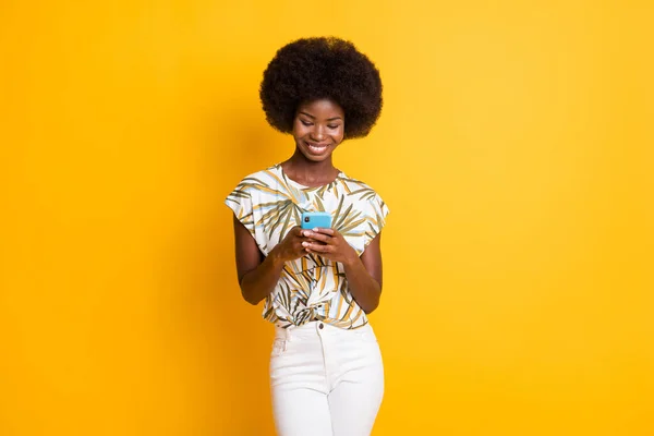 Photo of attractive pretty curly hair lady typing telephone wear print t-shirt isolated over vivid yellow color background