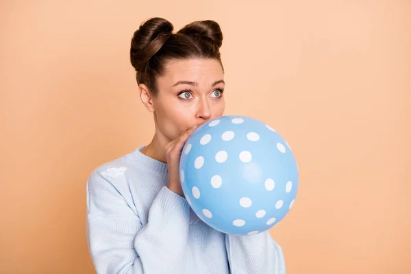Photo of optimistic nice brunette lady blow balloon look empty space wear blue sweater isolated on pastel beige color background — Stock Photo, Image