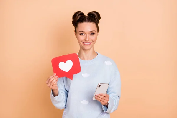 Fotografie optimistické brunetka dáma stojí držet telefon jako nošení svetr izolované na pastelové béžové barvy pozadí — Stock fotografie