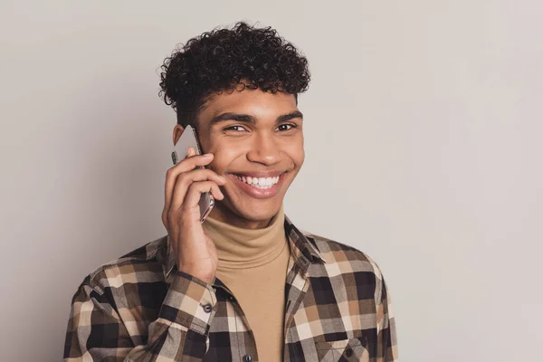 Foto van knappe brunette afro Amerikaanse man houden telefoon praten communicatie geïsoleerd op grijze kleur achtergrond — Stockfoto