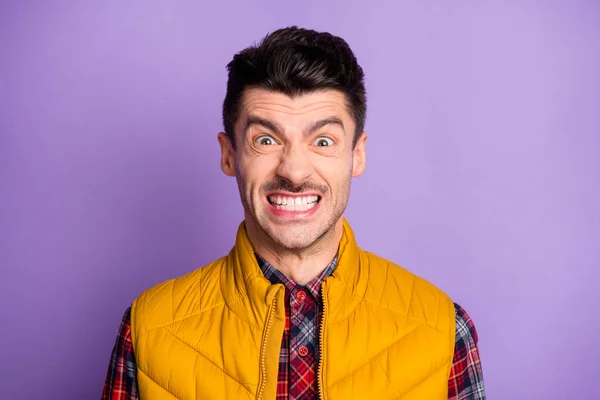 Photo d'un jeune homme furieux en colère portant une veste jaune sans manches montrant des dents isolées de couleur violette fond — Photo