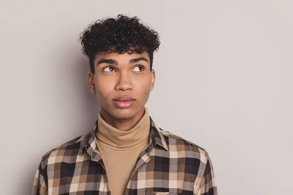 Foto de chico africano mirada curiosa espacio vacío creo que usar camisa a cuadros rollneck aislado fondo de color gris — Foto de Stock