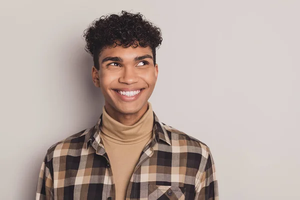Foto do cara interessado olhar espaço vazio branco sorriso desgaste xadrez camisa rollneck isolado cinza cor fundo — Fotografia de Stock