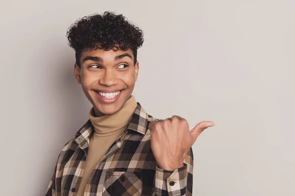 Perfil foto lateral do jovem afro-americano olhar ponto dedo polegar espaço vazio isolado no fundo de cor cinza — Fotografia de Stock