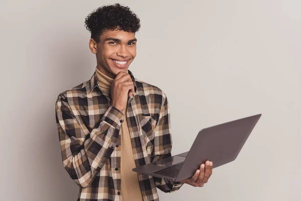 Foto van slimme Afrikaanse jongen vinger kin hold netbook slijtage geruite shirt geïsoleerde grijze kleur achtergrond — Stockfoto