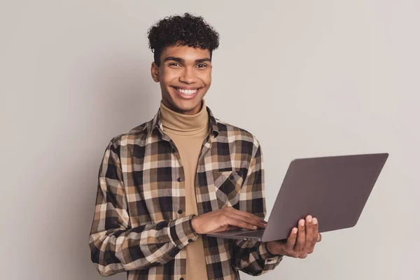 Foto portrét mladého chlapce v kostkované košili prohlížení internetu s notebookem studium izolované na šedém pozadí — Stock fotografie