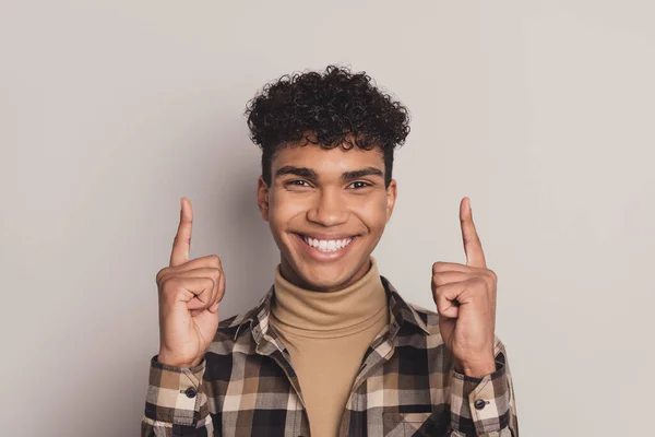 Foto de atraente homem afro-americano feliz apontar dedos para cima espaço vazio bom humor isolado em fundo de cor cinza — Fotografia de Stock