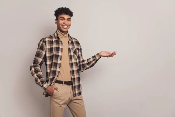 Foto do cara afro-americano encantador segurar mão bolso vazio espaço mão isolado no fundo de cor cinza — Fotografia de Stock