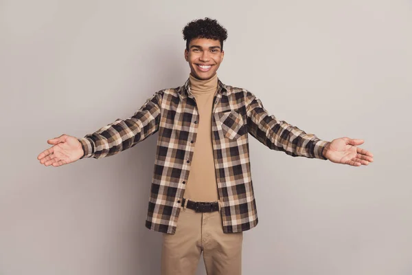 Foto retrato de menino na camisa xadrez abraçando mãos abertas sorridente bem-vindo isolado no fundo de cor cinza — Fotografia de Stock