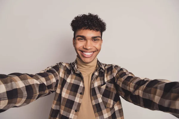 Foto ritratto di giovane ragazzo in camicia a quadri sorridente allegro prendendo selfie isolato su sfondo di colore grigio — Foto Stock