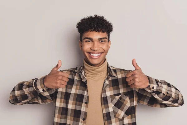 Foto van man heffen twee duimen omhoog witte glimlach dragen geruite shirt coltrui geïsoleerde grijze kleur achtergrond — Stockfoto