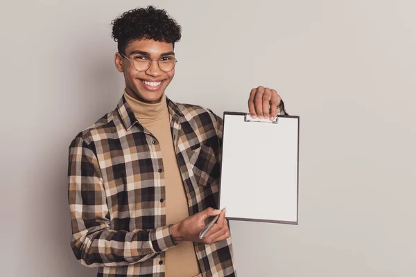 Foto portret van man tonen klembord met wit vel papier houden pen vragen zetten handtekening glimlachen geïsoleerd op grijze kleur achtergrond — Stockfoto