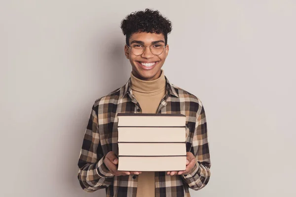 Foto portret van man houden boek stapel studeren voordat examens test glimlachen geïsoleerd op grijze achtergrond — Stockfoto