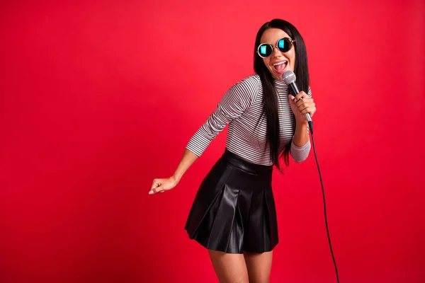 Retrato de atractiva talentosa vocalista alegre de pelo largo cantando single hit aislado sobre fondo de color rojo brillante — Foto de Stock