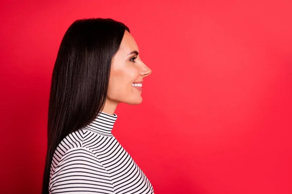 Profil sida foto av unga glada glada leende flicka ser copyspace slitage randig polotröja isolerad på röd färg bakgrund — Stockfoto