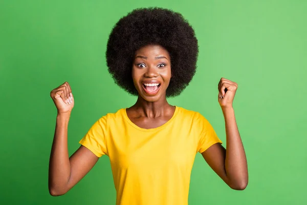 Foto av unga glada leende upphetsad galen afrikansk kvinna höja nävarna i seger framgång isolerad på grön färg bakgrund — Stockfoto