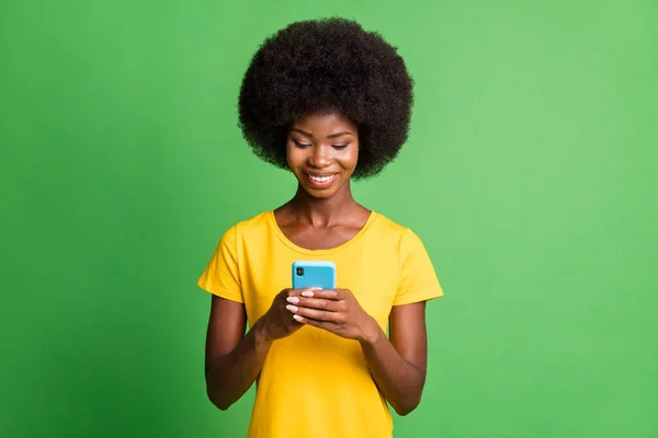 Zdjęcie młodego szczęśliwego dobrego nastroju afro dziewczyna blogger uzależniony od smartfona odizolowany na zielonym tle kolor — Zdjęcie stockowe