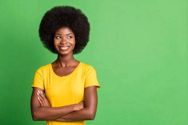 Foto av ung glad leende glad charmig afro flicka ser copyspace med korsade armar isolerade på grön färg bakgrund — Stockfoto