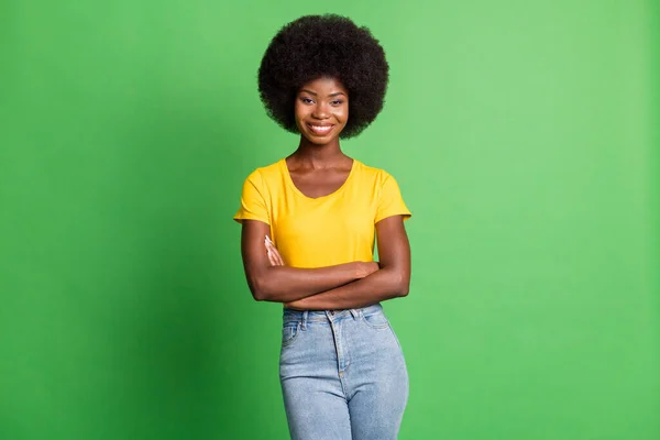 Retrato fotográfico de mujer confiada con brazos cruzados sonriendo en ropa casual aislada sobre un vibrante fondo de color verde — Foto de Stock