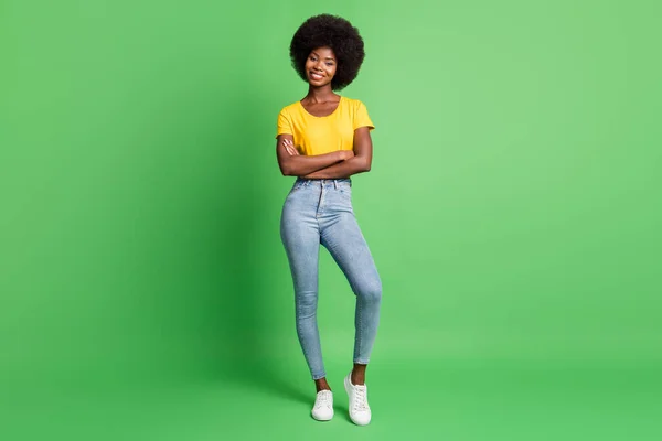 Pełnowymiarowe zdjęcie młodej szczęśliwej uśmiechniętej pięknej afro dziewczyny z skrzyżowanymi rękami odizolowane na zielonym tle koloru — Zdjęcie stockowe
