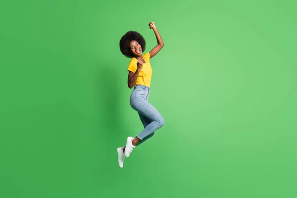 Ganzkörpergröße Foto von springenden Mädchen gestikuliert wie Sieger glücklich isoliert auf hellgrünem Hintergrund — Stockfoto