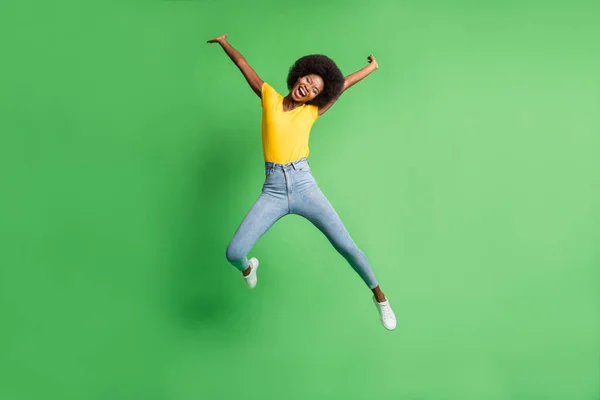 온몸의 전체 길이 점프하는 소녀의 사진 부주의 한 웃는 밝은 녹색 배경에 격리 — 스톡 사진