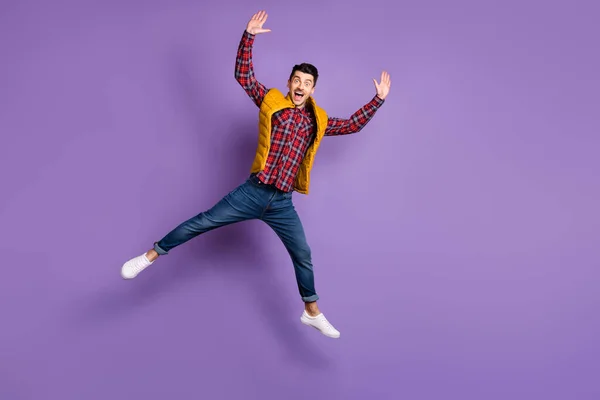 Foto de tamaño completo de chico optimista salto usar camisa jeans chaleco aislado sobre fondo de color violeta — Foto de Stock