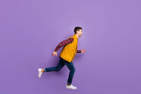 Foto de perfil em tamanho real de cara otimista salto corrida desgaste camisa jeans colete isolado no fundo violeta — Fotografia de Stock