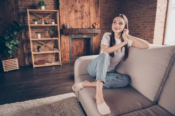 Φωτογραφία από αρκετά στοχαστική νεαρή γυναίκα λευκό t-shirt καθιστικό καναπέ έχοντας υπόλοιπο χαμογελώντας σε εσωτερικούς χώρους δωμάτιο διαμέρισμα — Φωτογραφία Αρχείου