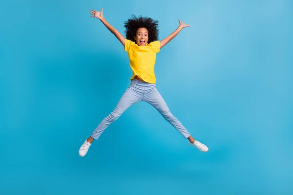Teljes hosszúságú fotó vidám afro amerikai barna lány ugrás csillag alakú emelje fel a kezét viseljen alkalmi ruhát elszigetelt kék színű háttér — Stock Fotó