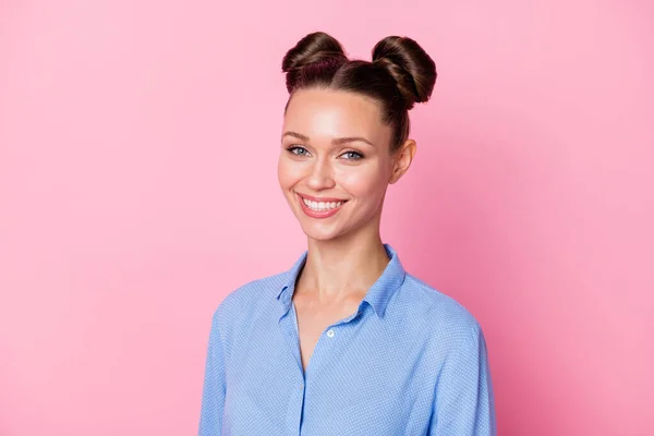 Foto ritratto di studentessa con acconciatura panino sorridente indossando camicia blu isolato su sfondo rosa pastello — Foto Stock